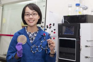 林曉青拿著真菌培養皿、像樂高的 okaramine 分子模型。這兩者藏著真菌殺蟲的秘密。圖│研之有物