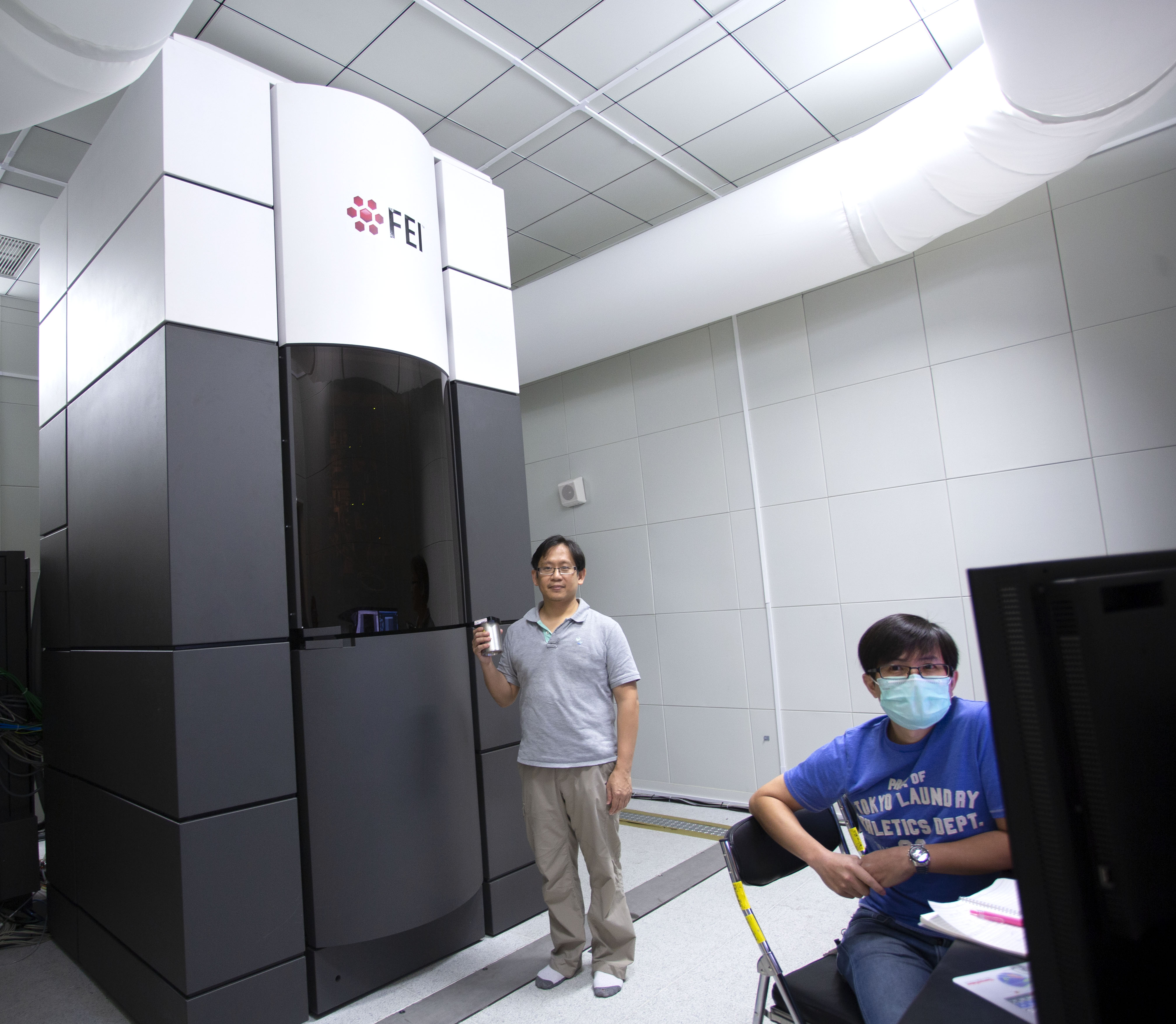 中研院的一台高階冷凍電子顯微鏡:Titan Krios。為了不干擾冷凍電顯的觀測,整個環境設計為防震、吸音、控溫、控濕,一絲絲微風也沒有。圖中立者為中研院生化所副研究員何孟樵, 坐者為冷凍電顯中心經理張淵智。圖│研之有物